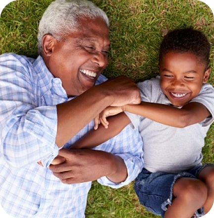 Older adult and child lying on grass